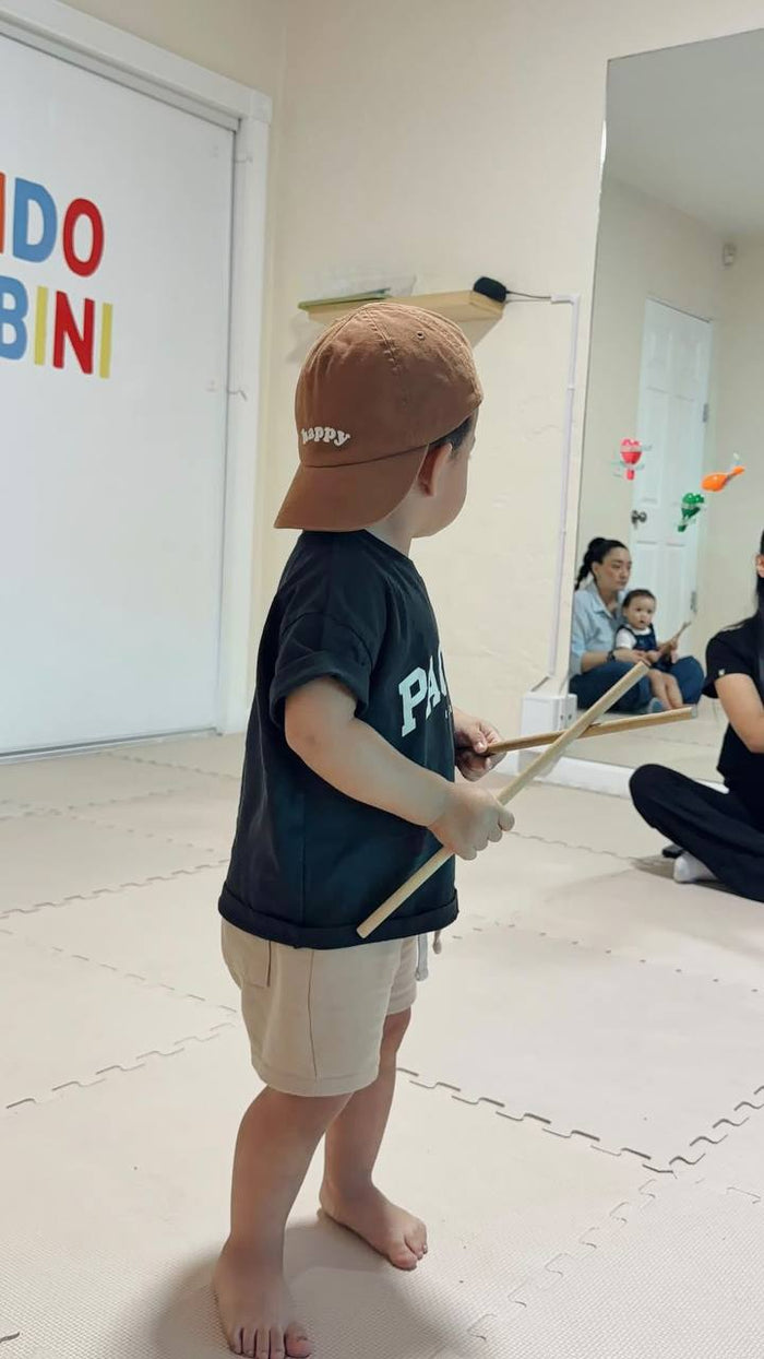 Niño jugando con palitos de ritmo